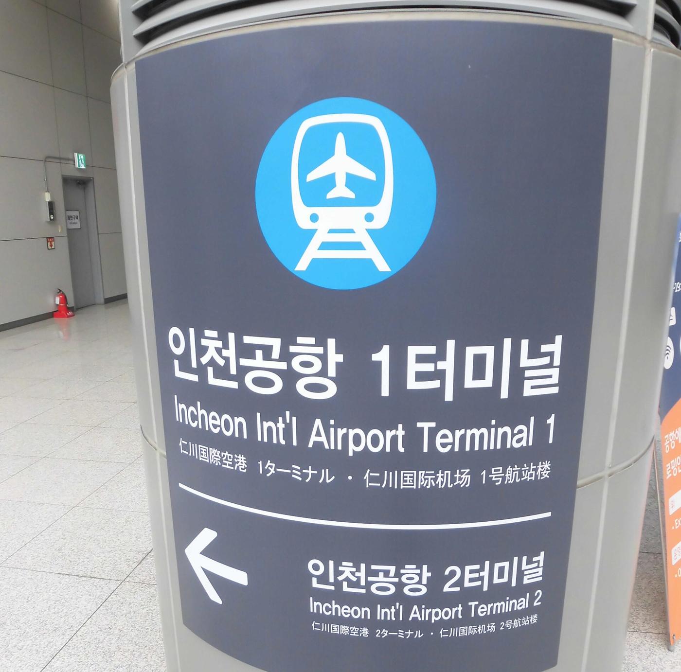 The station name sign at Incheon International Airport Terminal 1 station on the Airport Railroad, with an arrow to Terminal 2.