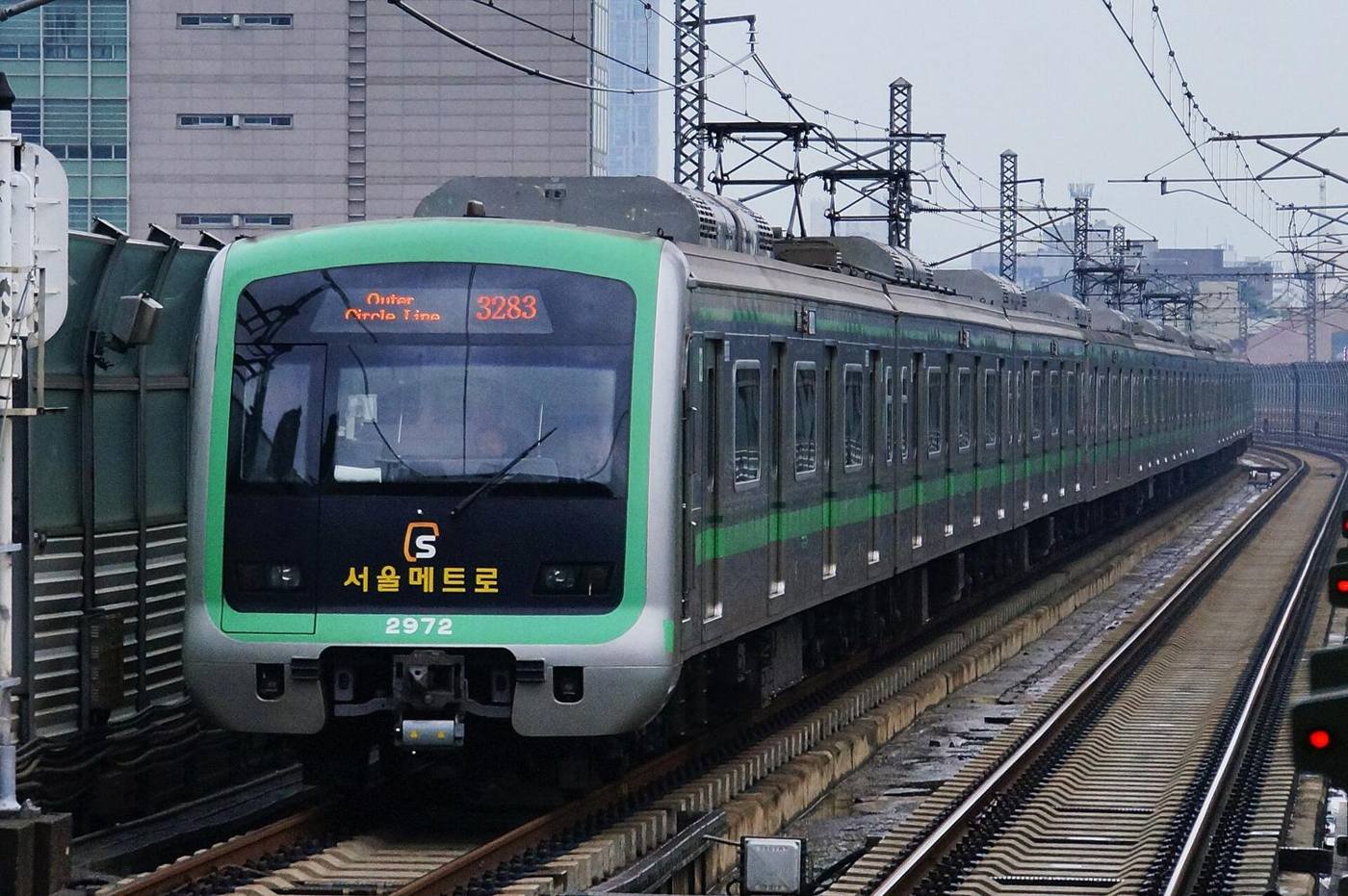 A green-fronted Seoul Metro Line 2 train, destination sign reading Outer Circle Line, arriving on an elevated track.