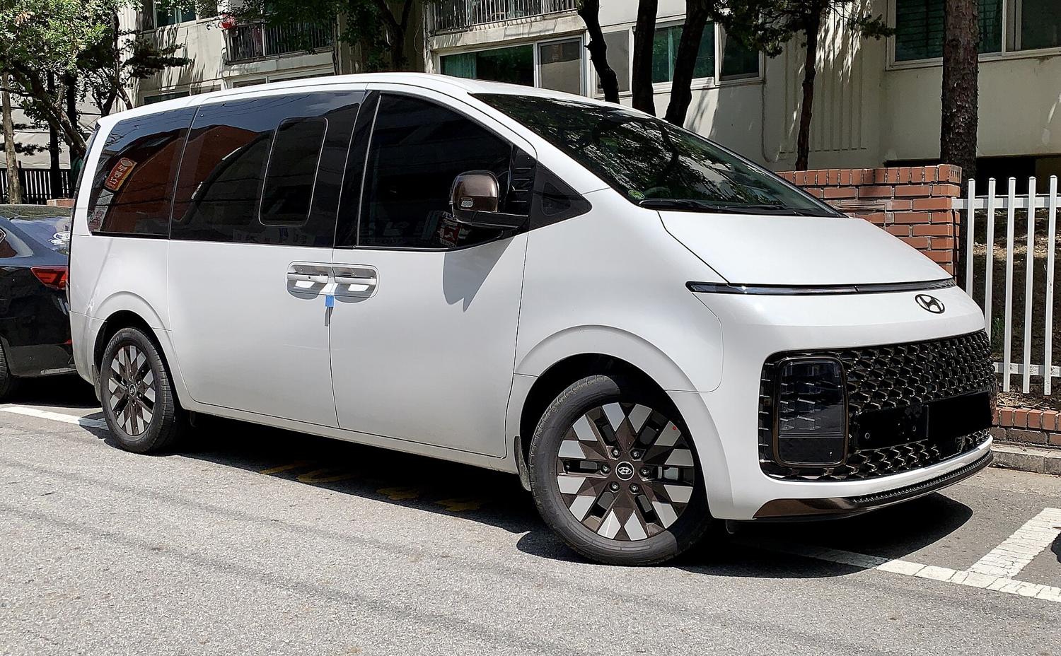 A white Hyundai Staria van parked on a Seoul side street, its sliding door and dark windows visible.