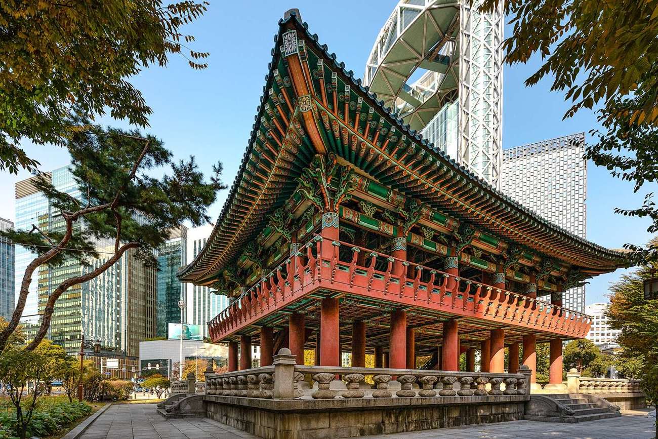 Bosingak bell pavilion in Jongno, a painted wooden pavilion on a stone base, with Jongno Tower's steel lattice rising behind it.