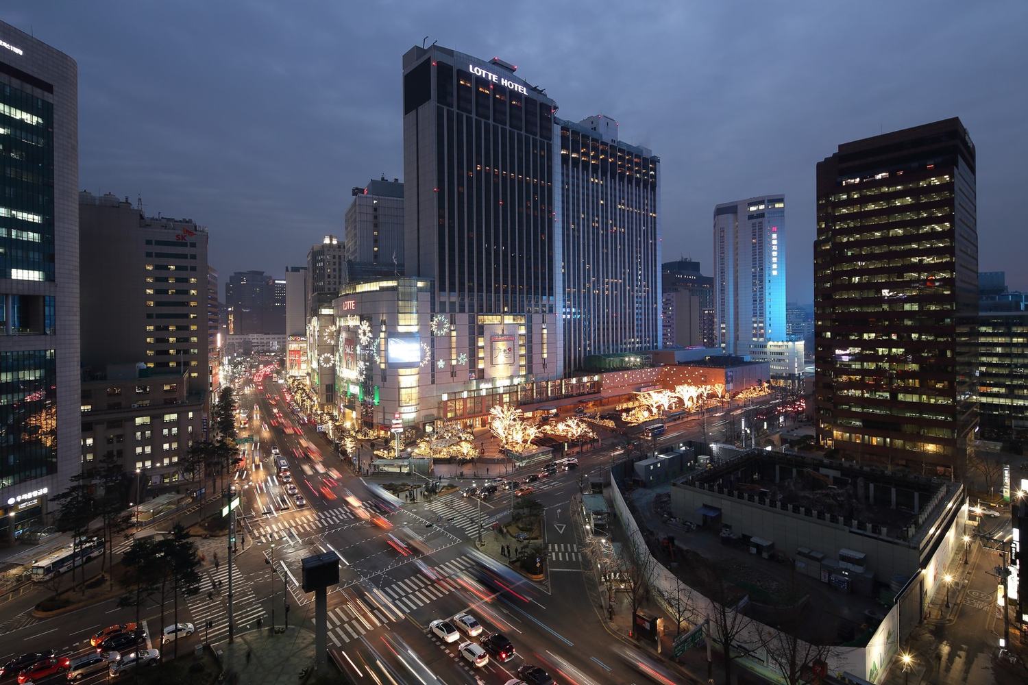 Night view of the Euljiro 1-ga intersection with the Lotte Hotel Seoul towers and Lotte Department Store lit up in Sogong-dong.