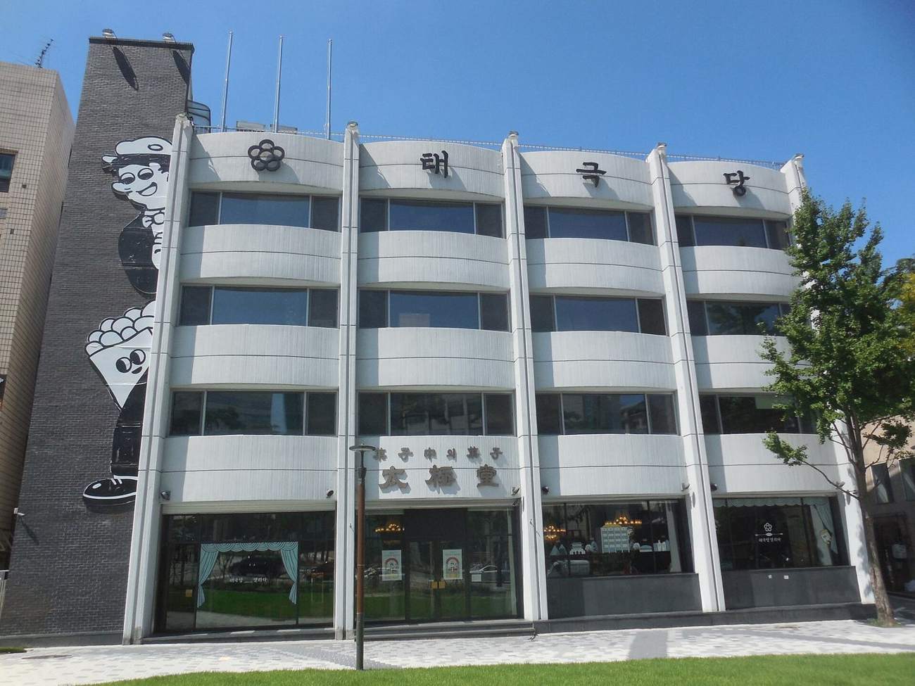 The front of Taegeukdang bakery in Jangchung-dong, Seoul, a four-storey white building with 태극당 in large letters across the top.