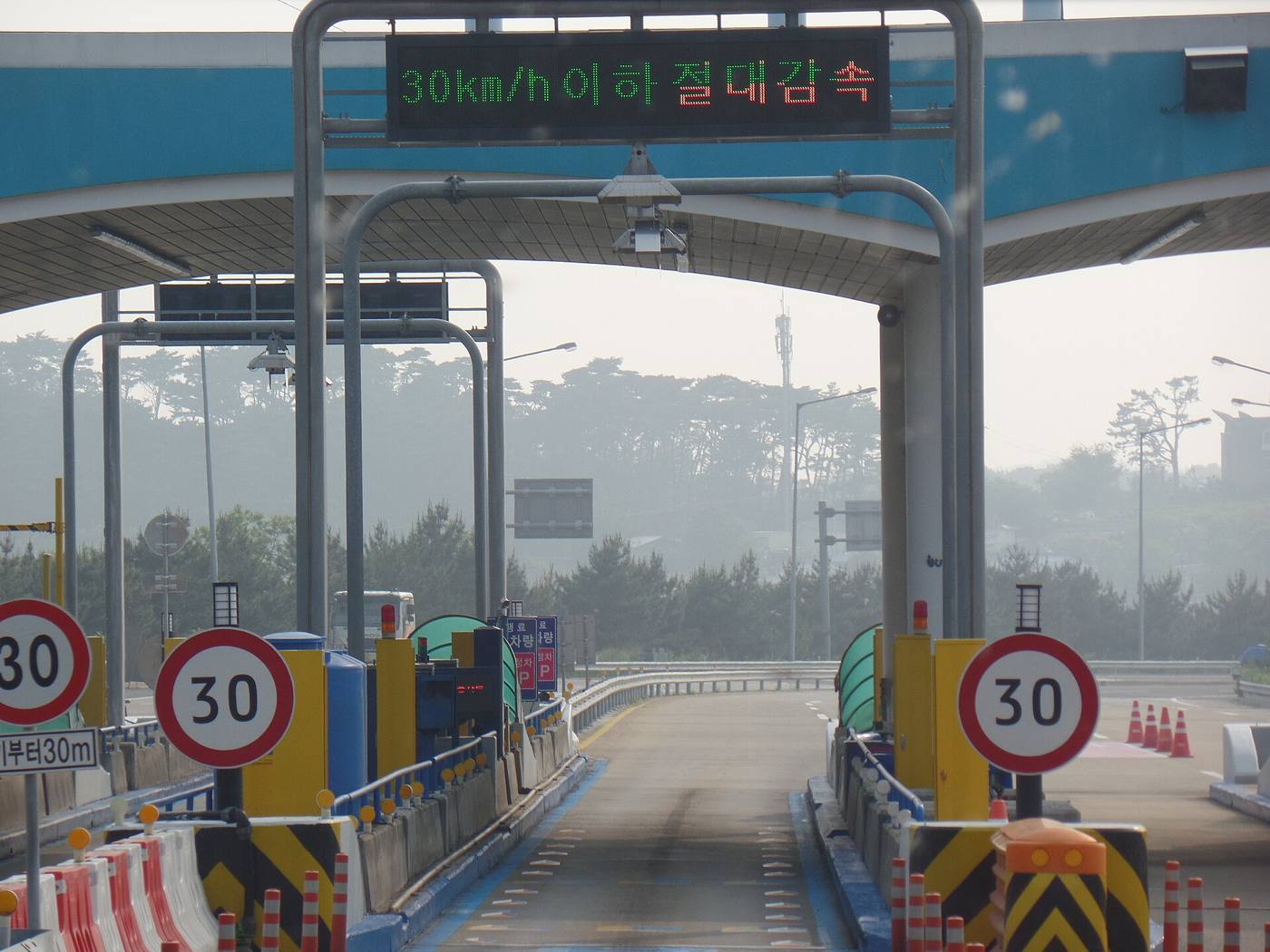 A Hi-Pass-only exit lane at Daecheon toll gate on the Seohaean Expressway, with 30 km/h signs and an overhead display reading "30km/h 이하 절대감속".