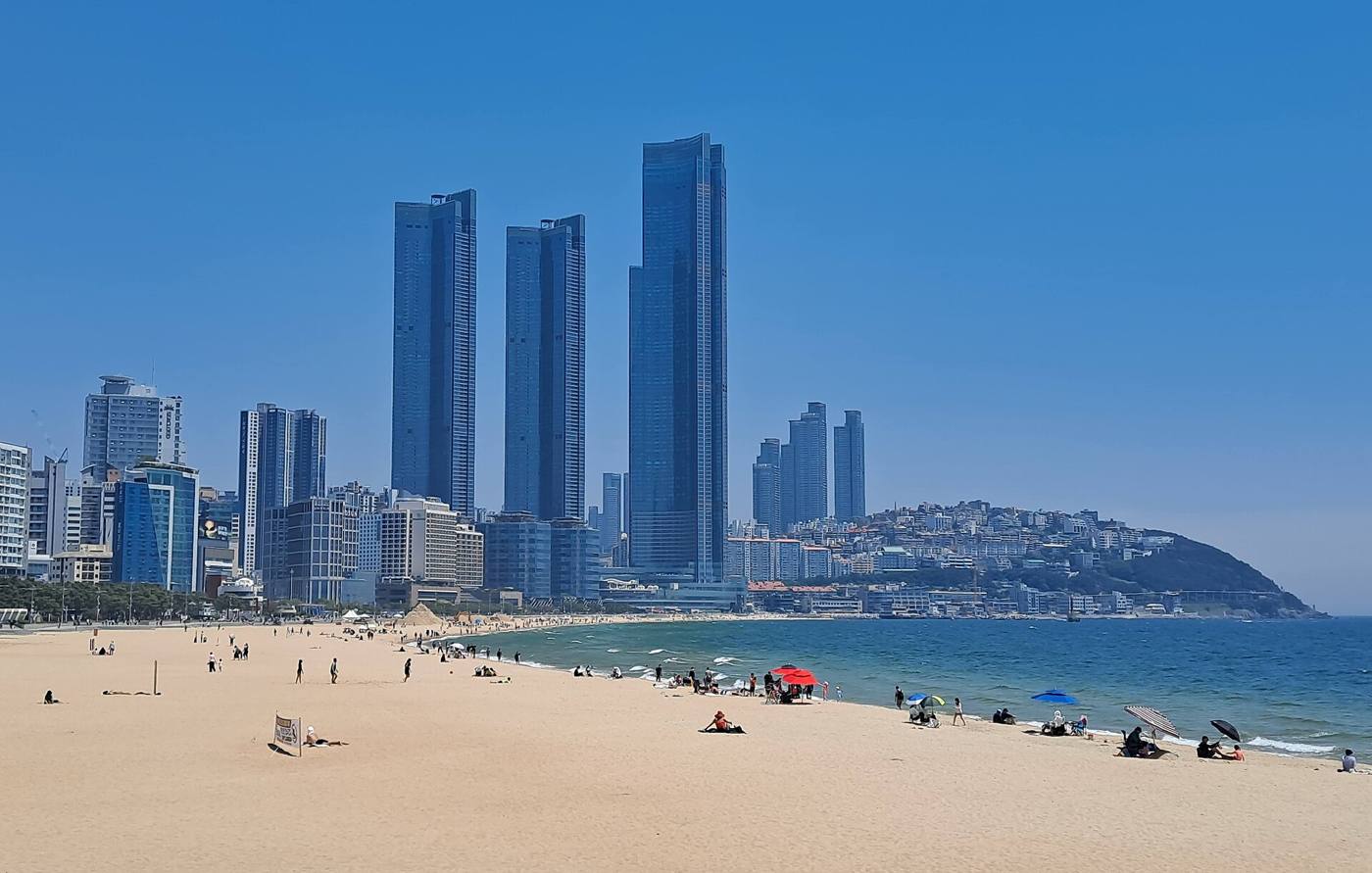 Haeundae Beach in Busan in May 2024, the sand and sea in the foreground and the high-rise skyline behind.