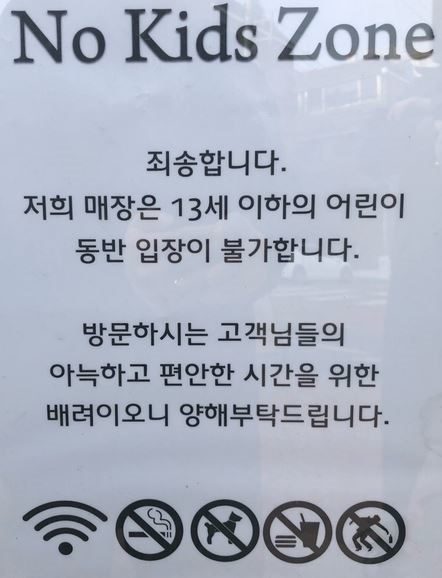 A printed shop notice headed No Kids Zone, which says in Korean that children aged 13 and under may not enter, for the comfort of other customers, with icons for wifi, no smoking, no pets, no outside food and a crossed-out figure.