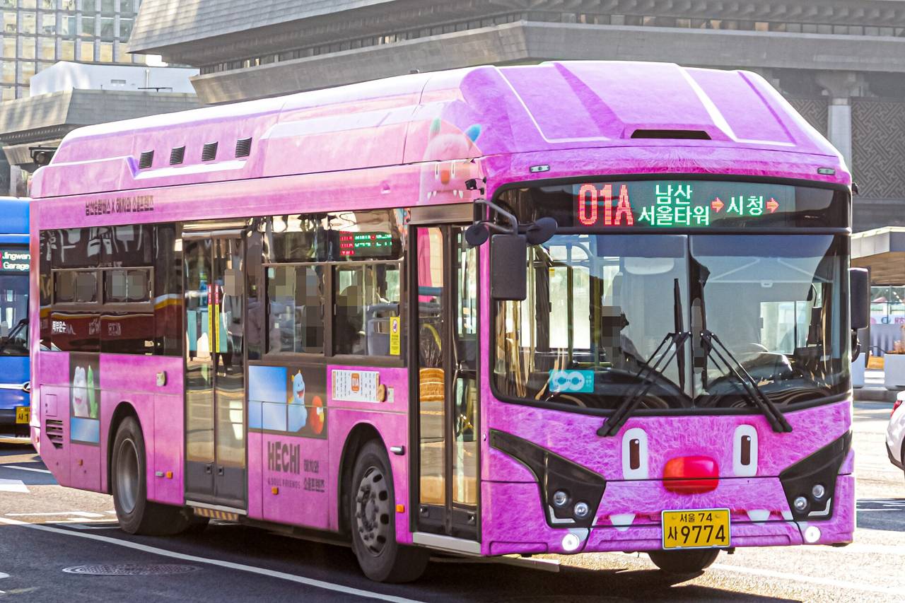 A pink Hechi-wrapped low-floor bus showing route 01A, Namsan Seoul Tower to City Hall, on its destination display.