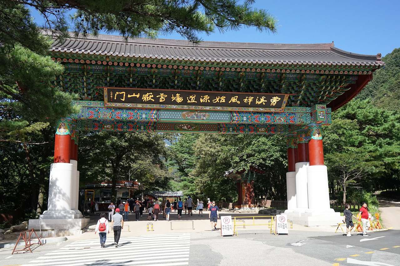 Seoraksan's Sogongwon entrance gate, a traditional roofed gate with visitors walking through it.