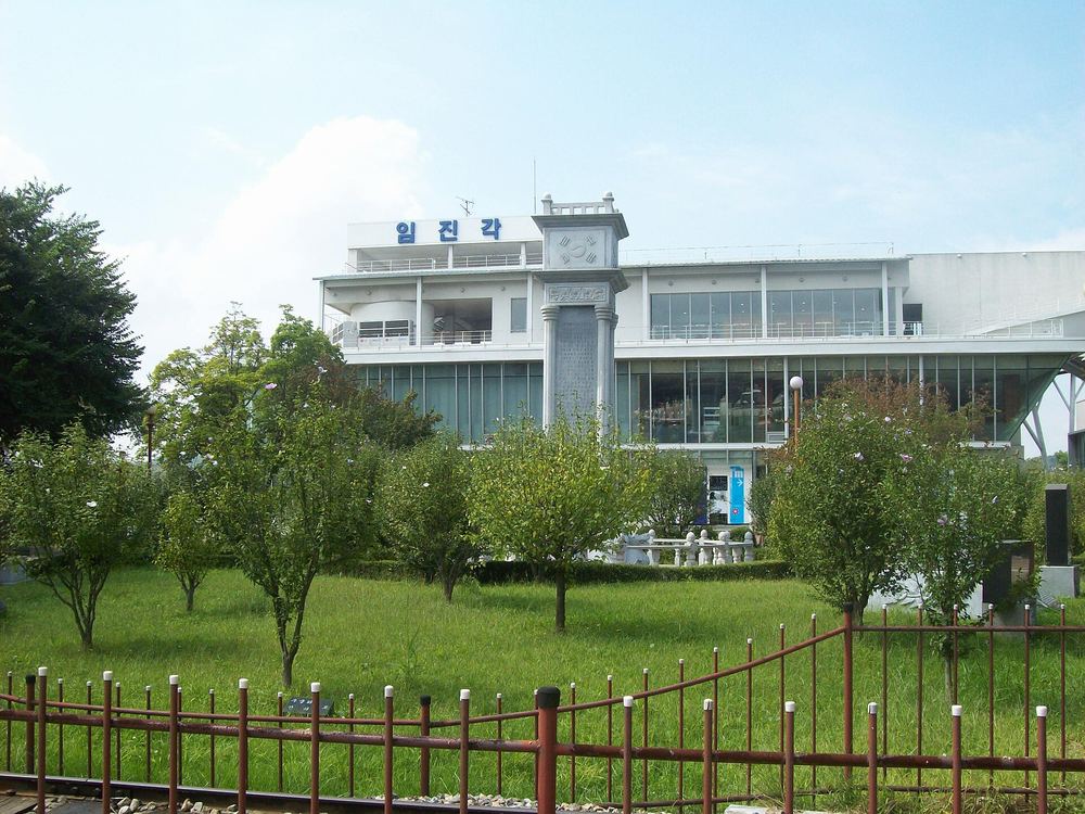 The Imjingak building in Paju in September 2008: a white multi-storey building with the sign 임진각 on its roof, behind a lawn with young trees and a low red fence.