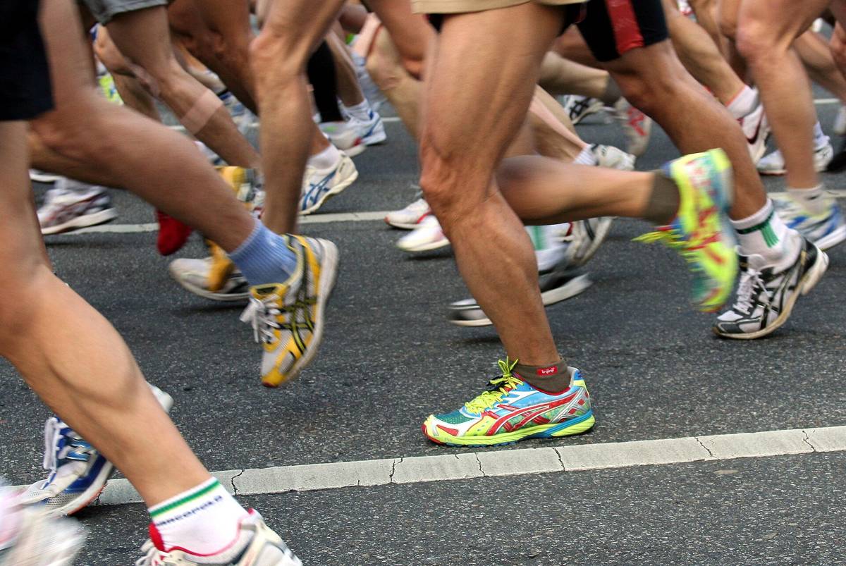 A close-up of runners' legs and colourful running shoes in a tightly packed field on a Seoul road during the 2008 Seoul International Marathon.
