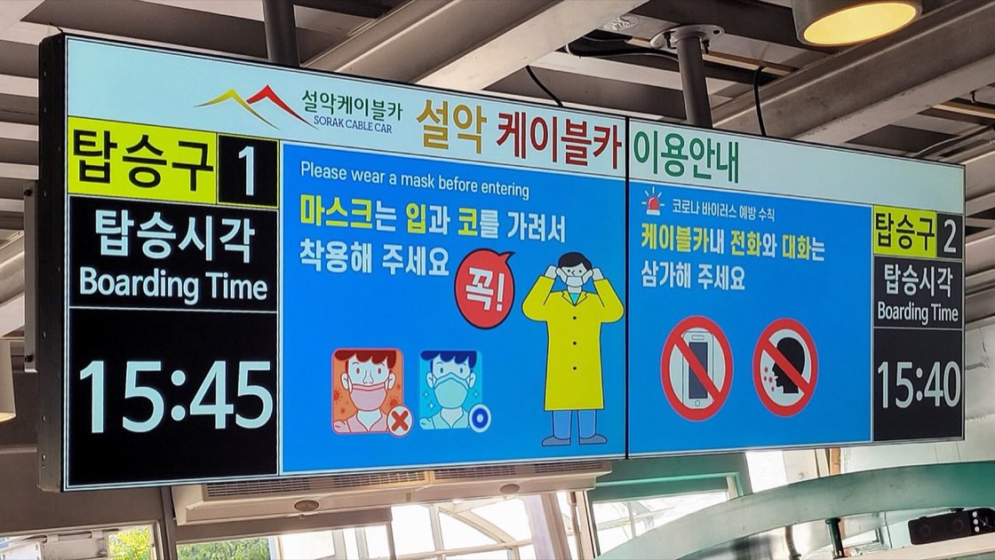 An electronic board at the Seorak cable car station headed 설악 케이블카 이용안내, with gate 1 showing Boarding Time 15:45 and gate 2 showing Boarding Time 15:40 on either side of safety notices, October 2022.